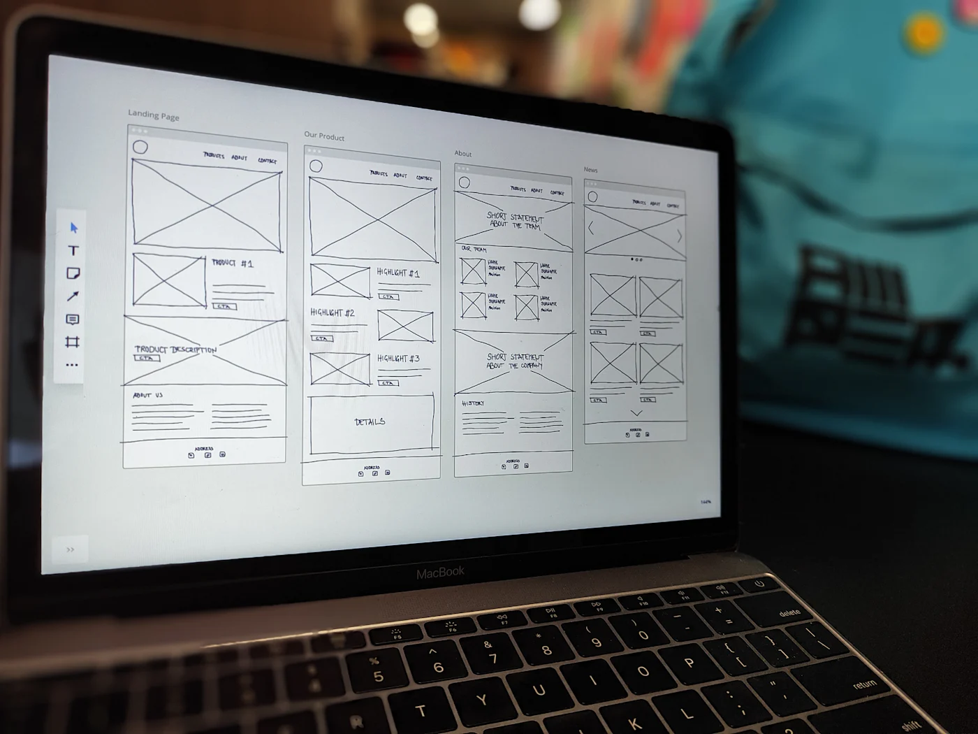 Laptop mostrando en pantalla los wireframes de varias páginas de un sitio web.